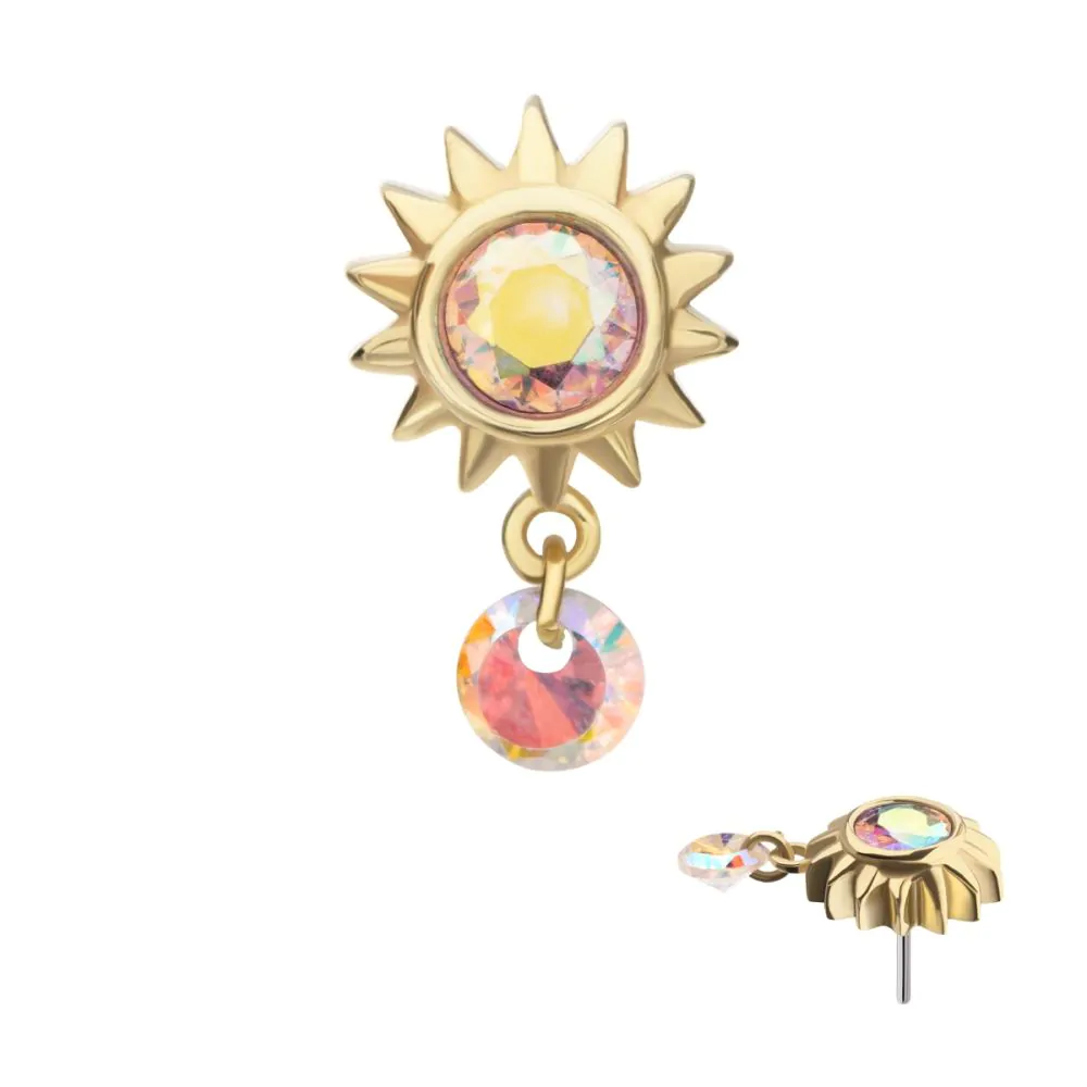 A 14k gold-colored sunburst-shaped body jewelry with a dangle design, featuring a multicolored gemstone in the center, and a second gemstone hanging from the jewelry.