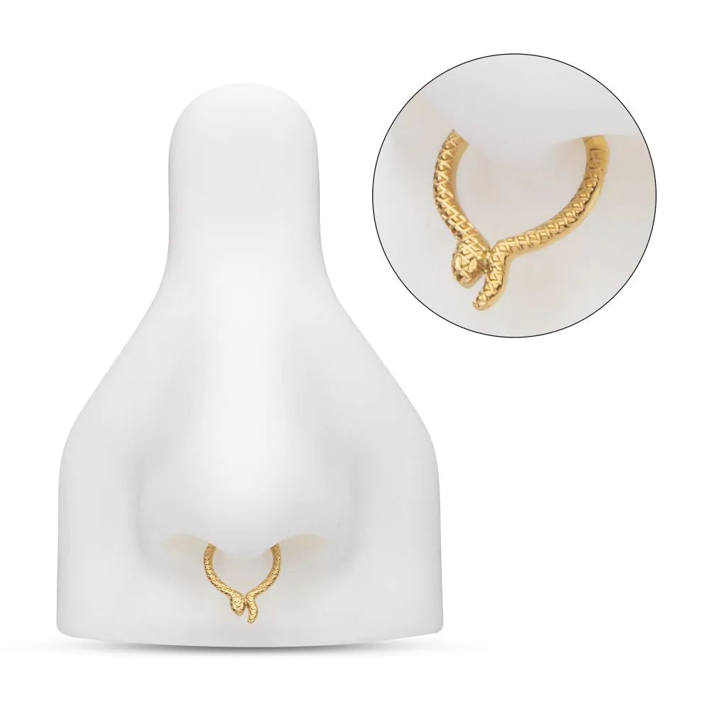 A 24k gold-colored snake-patterned clicker for body jewelry, accompanied by a matching smaller clicker with a different design, as displayed in a model nose with a separate close-up shot.