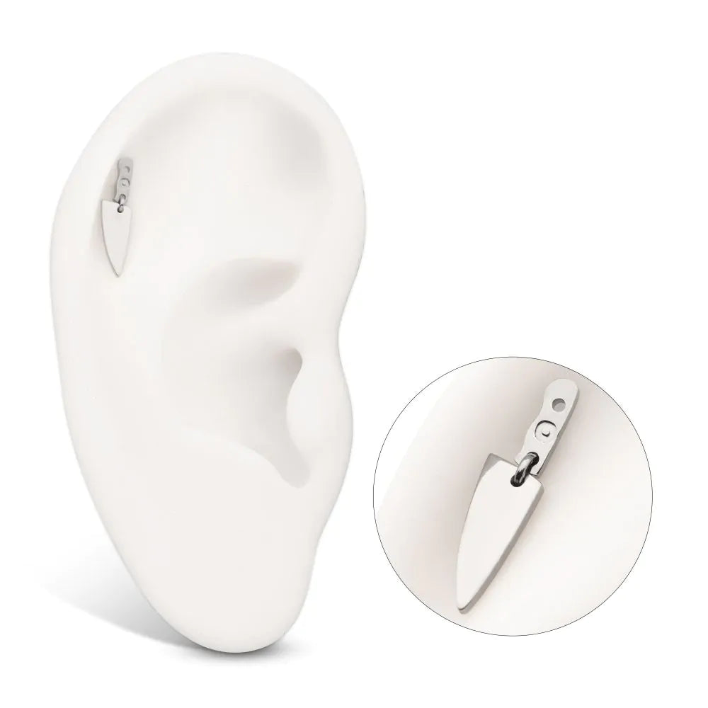 A silver-colored dangly dagger-shaped body piercing jewelry piece with a flatback post attachment point, shown in a model ear with a close-up view as well.