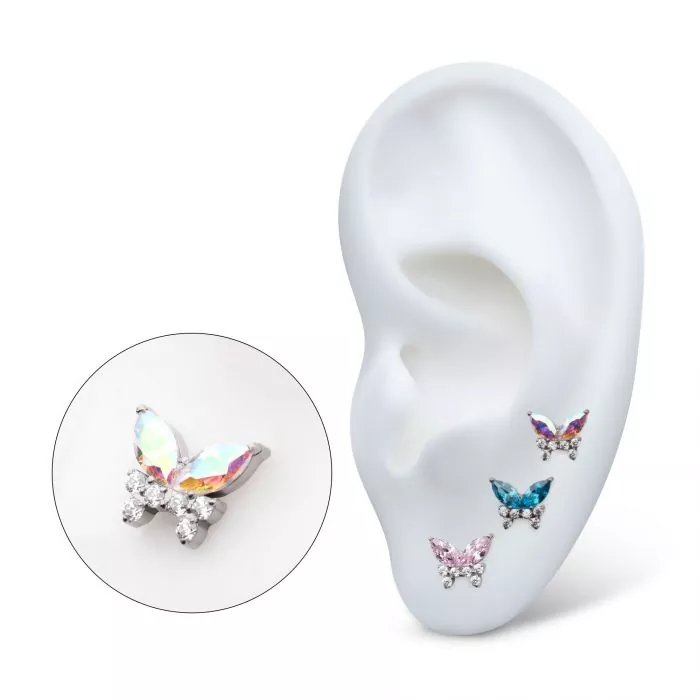 A collection of 14k gold two-tone swarovski butterfly stud earrings in various colors, as shown on display in a model ear.